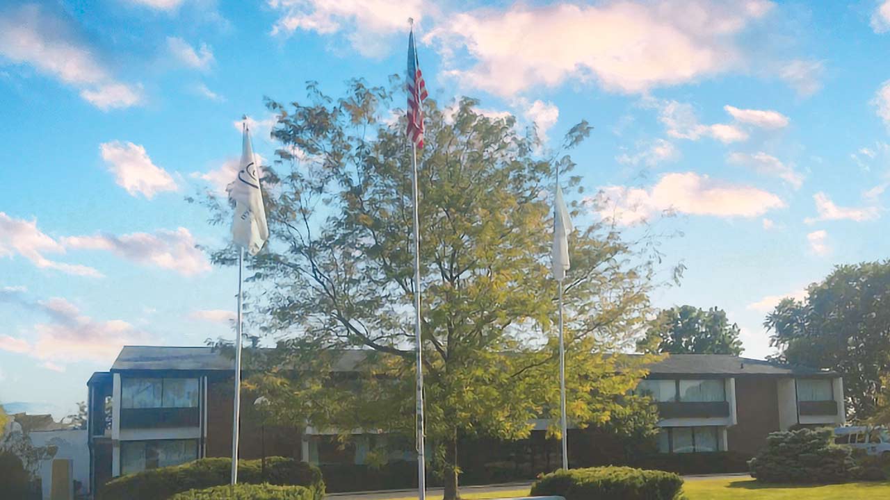 Cozy assisted living units with flagpoles and a manicured lawn at Flanagan Senior Living in Flanagan, IL, Livingston County.