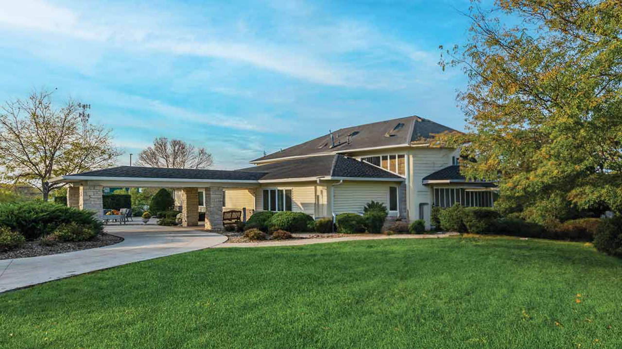 Modern single-story beige residential care and memory care building at Pinicon Senior Living in Anamosa, IA, Jones County.