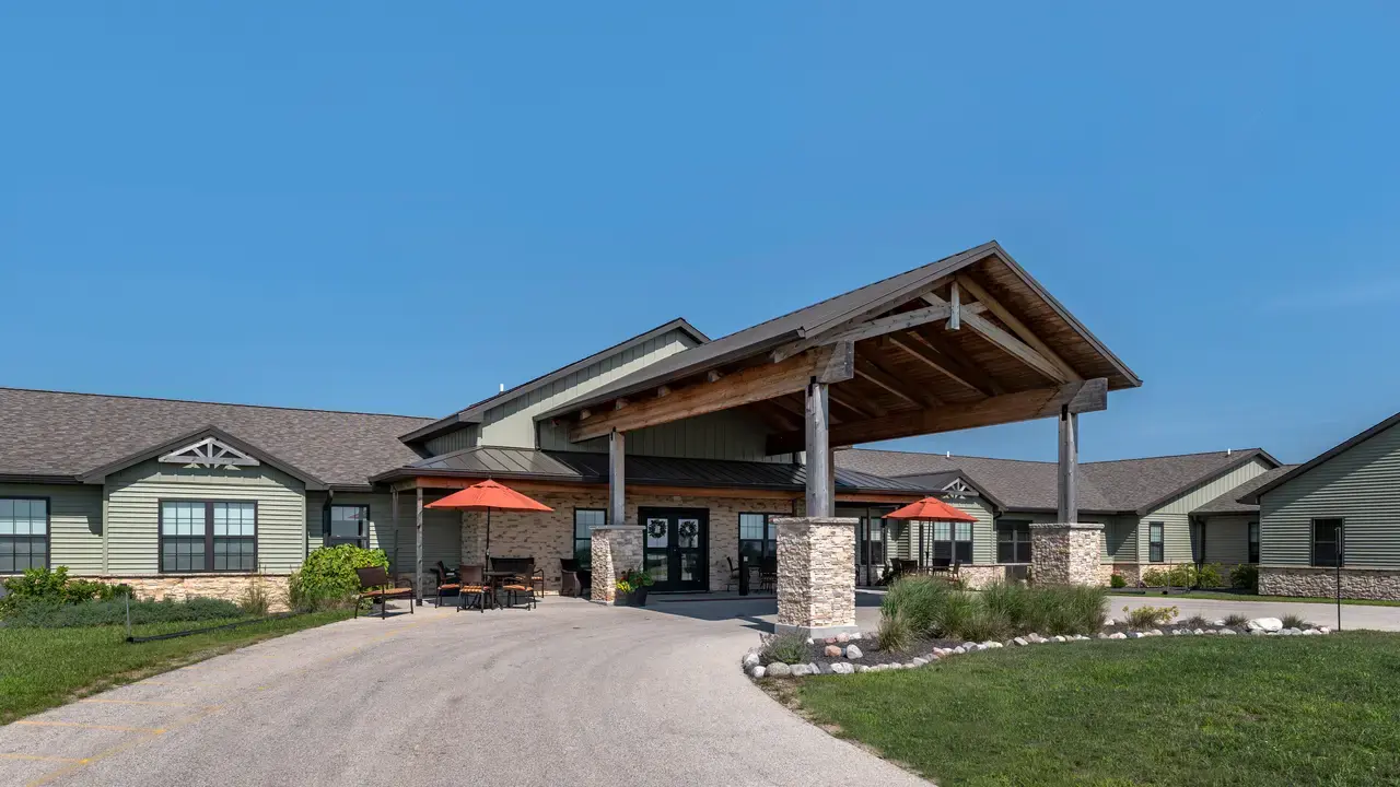 Rustic lodge-style single-story building with a wooden and stone facade at The Lodge at Manito Assisted Living &amp; Memory Care in Manito, IL, Mason County.
